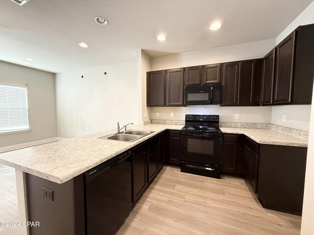 kitchen featuring kitchen peninsula, sink, light hardwood / wood-style floors, and black appliances