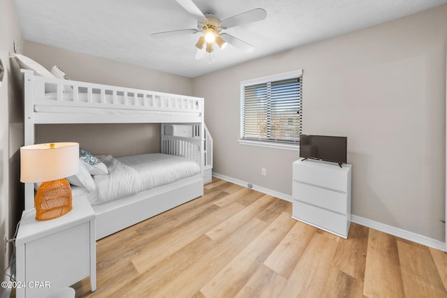 bedroom with hardwood / wood-style flooring, ceiling fan, and a textured ceiling