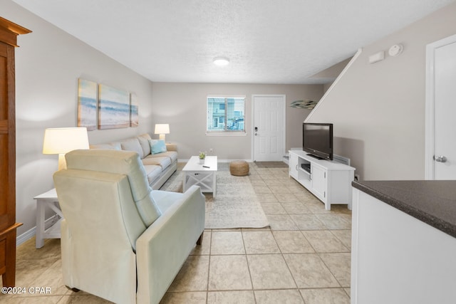 living room with a textured ceiling and light tile patterned flooring