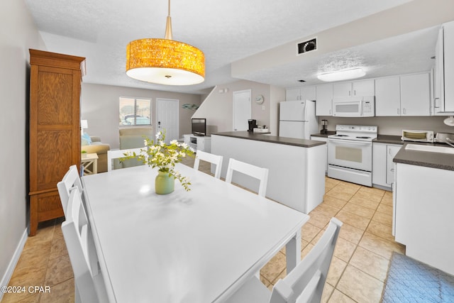 dining room featuring light tile patterned floors and a textured ceiling