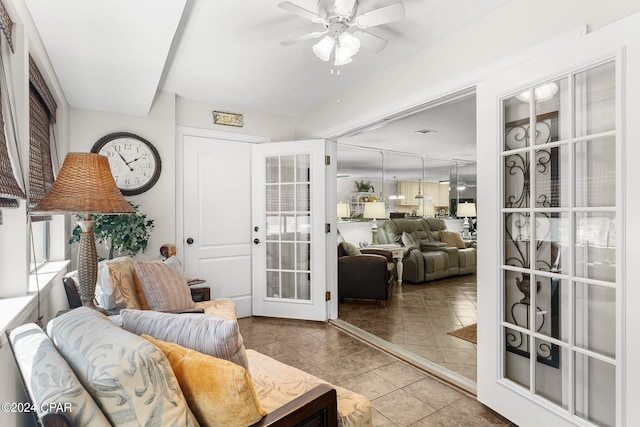 tiled living room with french doors and ceiling fan