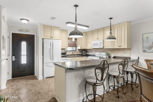 kitchen featuring white appliances, pendant lighting, and kitchen peninsula