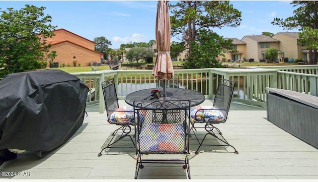 deck with area for grilling and a water view