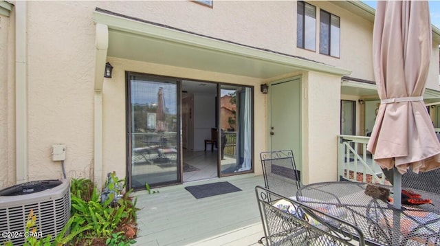 doorway to property with central AC unit and a deck