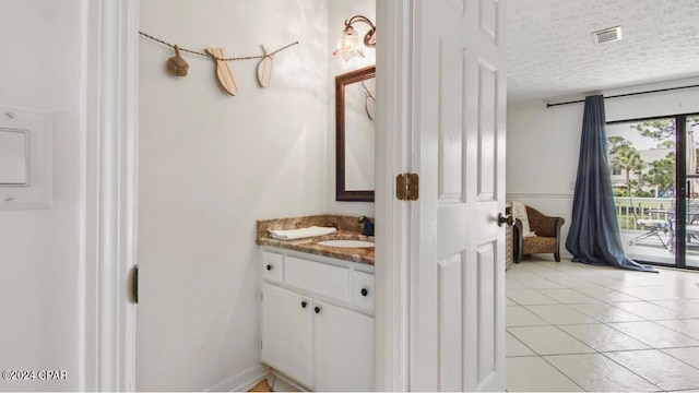 bathroom featuring tile patterned floors, vanity, and a textured ceiling