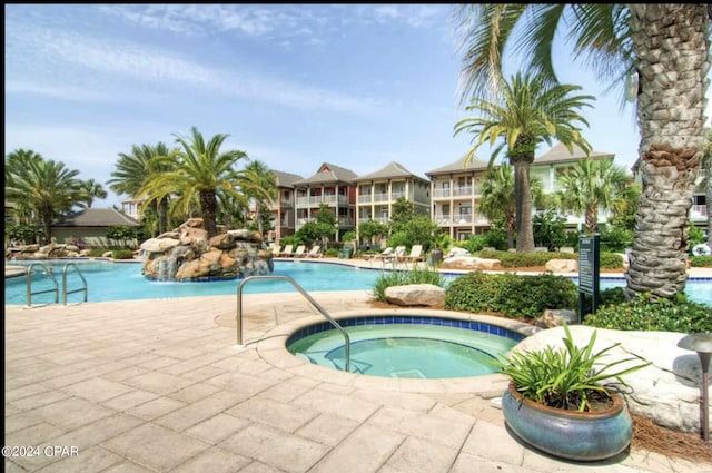 view of swimming pool with a community hot tub and a patio area