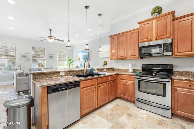 kitchen featuring pendant lighting, ornamental molding, sink, stone counters, and stainless steel appliances