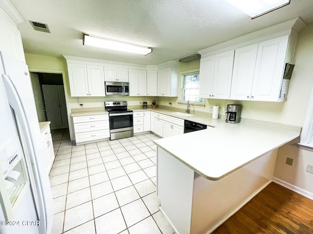 kitchen featuring sink, white cabinets, kitchen peninsula, and stainless steel appliances