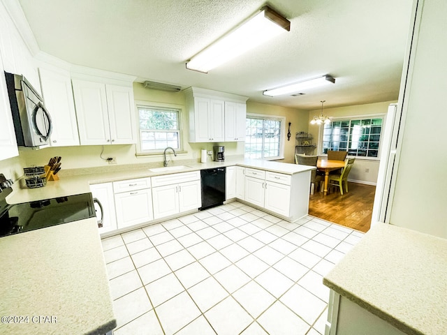 kitchen with kitchen peninsula, black dishwasher, plenty of natural light, and pendant lighting