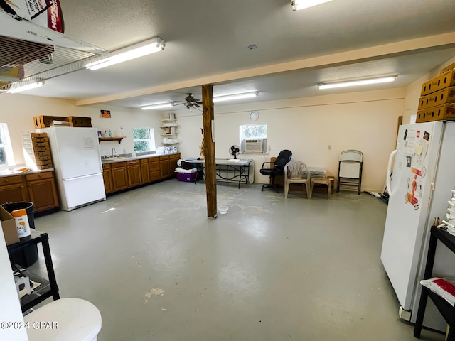 basement with white fridge, ceiling fan, and cooling unit