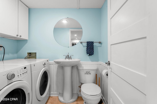 washroom featuring light tile patterned flooring, washing machine and dryer, and sink