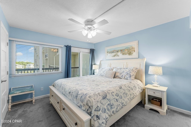 bedroom with ceiling fan, dark carpet, and a textured ceiling