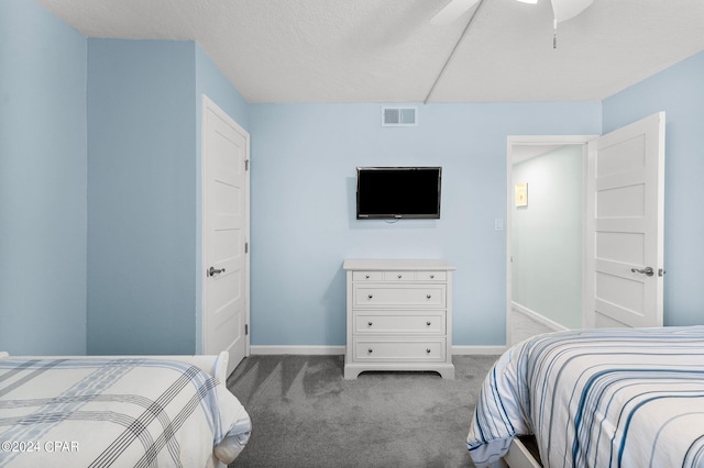 carpeted bedroom featuring ceiling fan and a textured ceiling