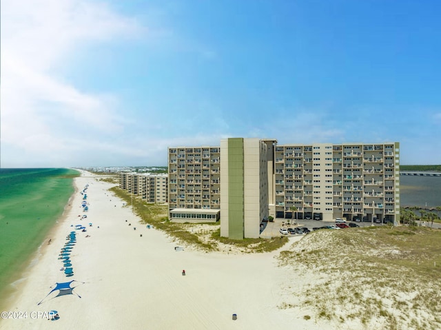 drone / aerial view with a water view and a beach view