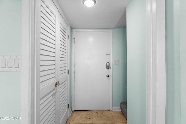 entryway featuring a textured ceiling and light tile patterned flooring