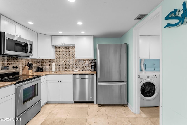 kitchen with sink, decorative backsplash, white cabinetry, stainless steel appliances, and washer / clothes dryer