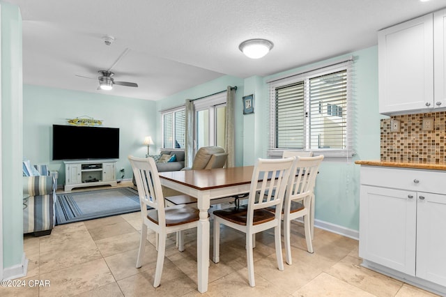 dining space featuring a textured ceiling, ceiling fan, and light tile patterned flooring