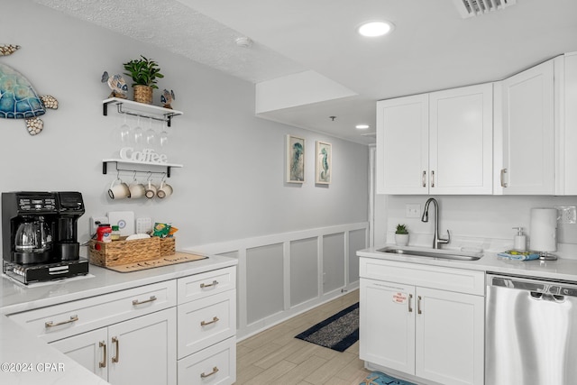 kitchen with white cabinetry, stainless steel dishwasher, and sink