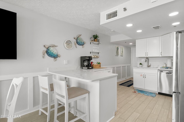 kitchen featuring sink, white cabinetry, a kitchen breakfast bar, and stainless steel appliances