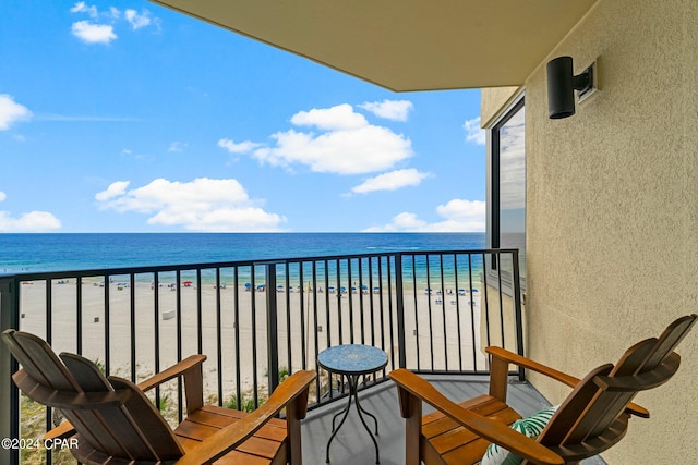 balcony featuring a water view and a view of the beach