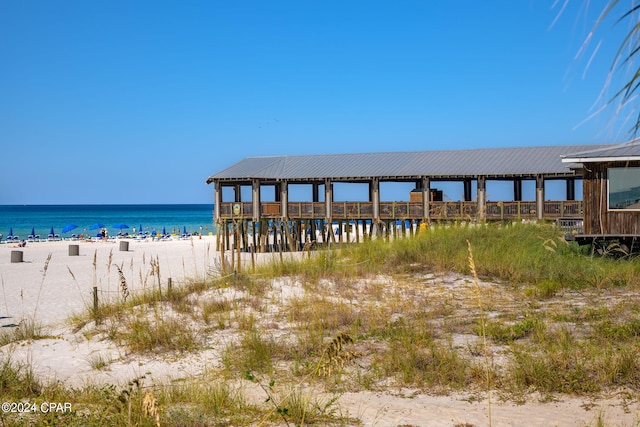 view of dock featuring a water view and a view of the beach