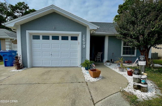 ranch-style house with central AC unit and a garage