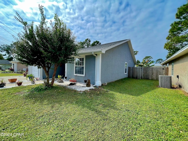 exterior space with cooling unit and a lawn