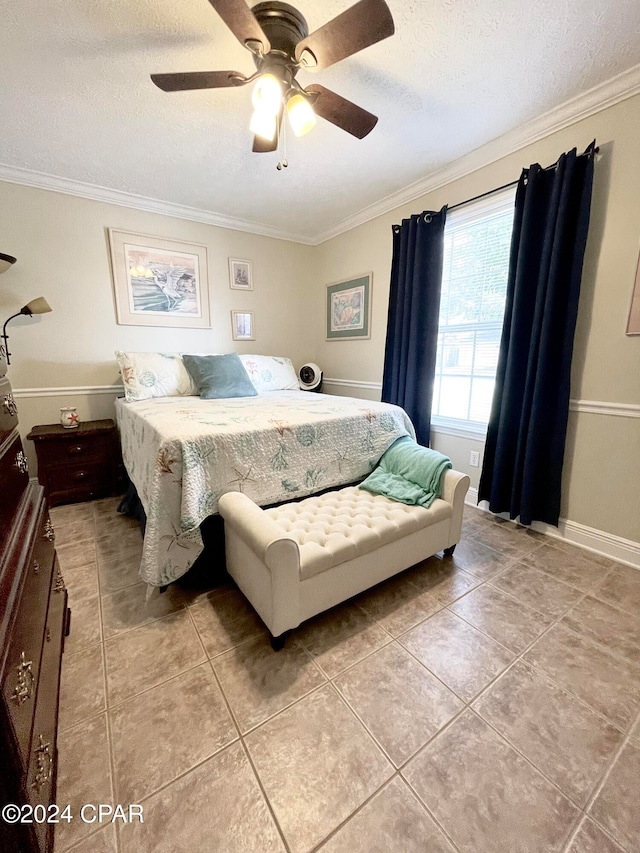 tiled bedroom featuring ceiling fan, a textured ceiling, and ornamental molding