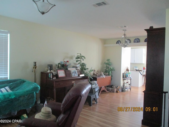 interior space with light hardwood / wood-style floors and a notable chandelier