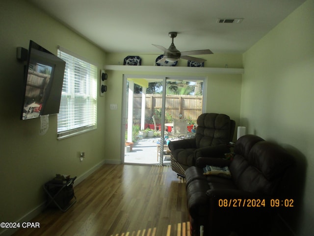 living room featuring wood-type flooring and ceiling fan