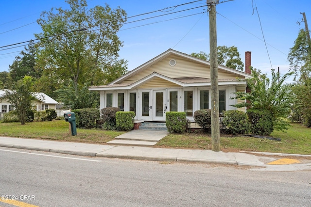 view of front of home with a front lawn and french doors