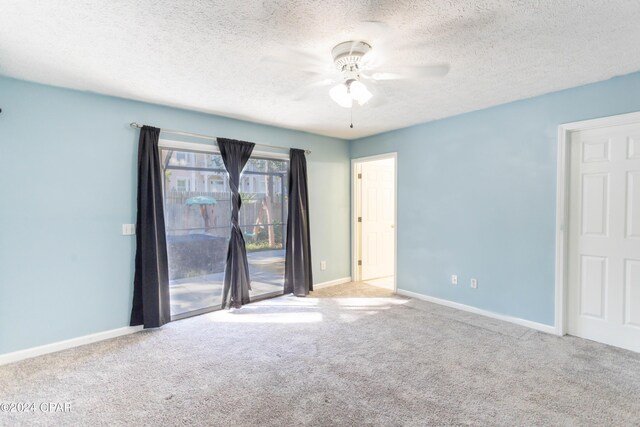 carpeted empty room featuring a textured ceiling and ceiling fan