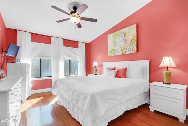 bedroom featuring ceiling fan, wood-type flooring, and vaulted ceiling