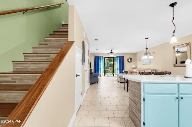 kitchen with blue cabinetry, ceiling fan, light tile patterned floors, and hanging light fixtures