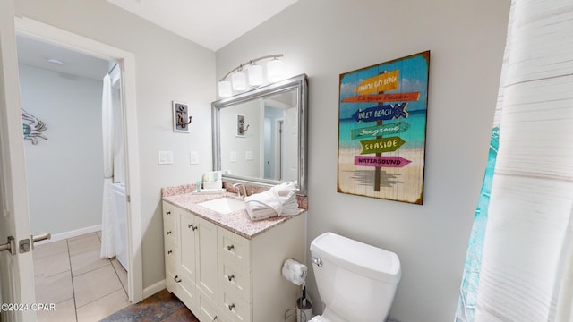 bathroom with vanity, toilet, tile patterned floors, and vaulted ceiling