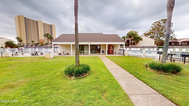 view of front of house with a patio area, a front lawn, and a community pool