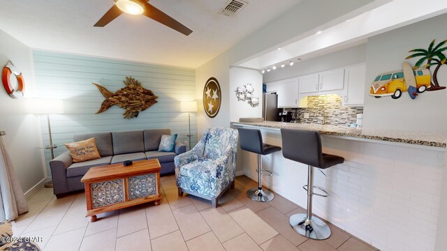 living room featuring ceiling fan and light tile patterned floors