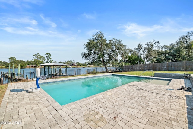 view of swimming pool featuring a patio and a water view