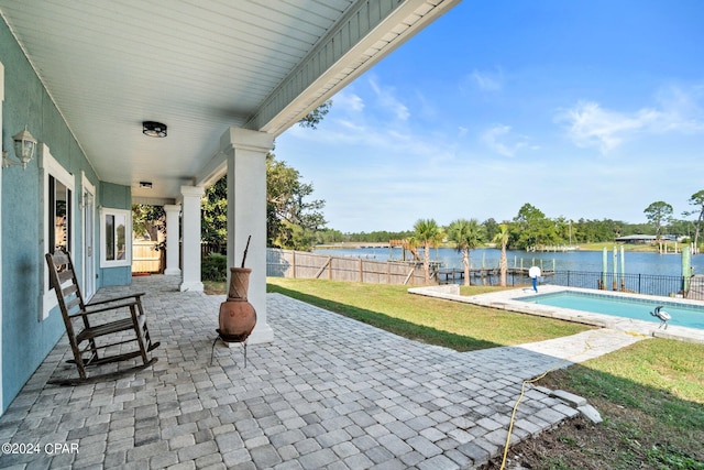 view of patio / terrace featuring a fenced in pool and a water view