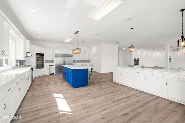 kitchen featuring pendant lighting, a center island with sink, and a kitchen breakfast bar