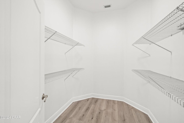 walk in closet with wood-type flooring