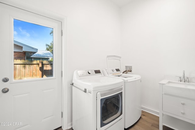 laundry area featuring plenty of natural light, washing machine and dryer, and hardwood / wood-style flooring