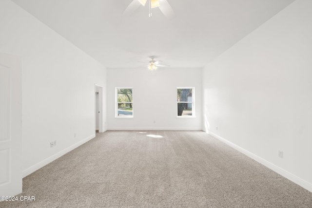 empty room featuring ceiling fan and carpet