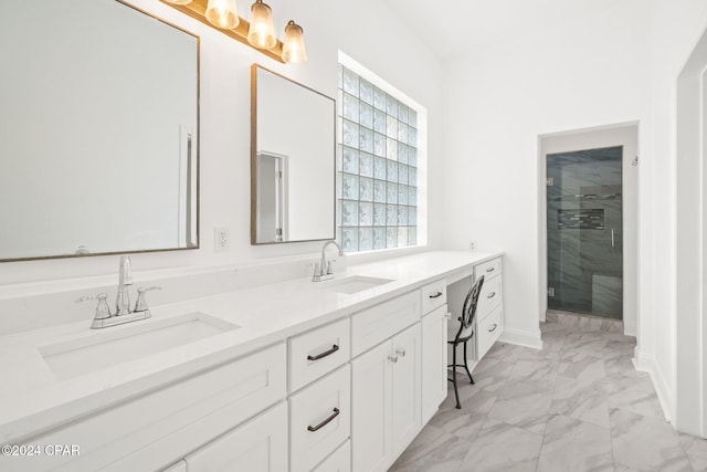 bathroom featuring a shower with door and vanity