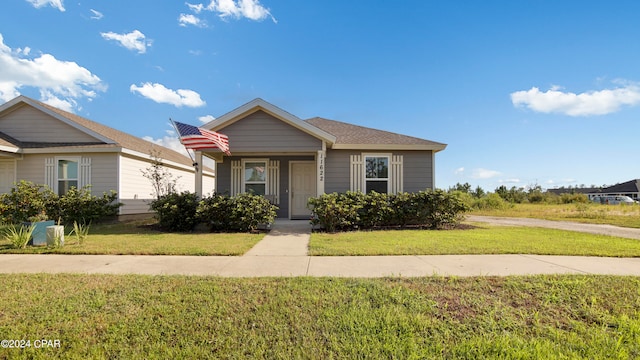 bungalow featuring a front lawn