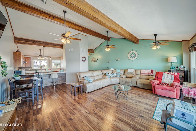 living room featuring vaulted ceiling with beams, a textured ceiling, and wood-type flooring