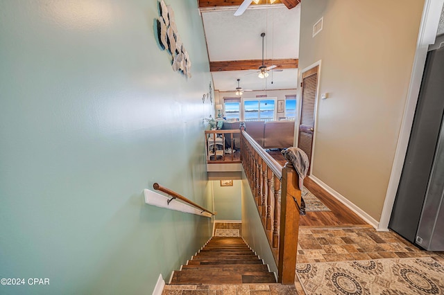 staircase with beam ceiling, hardwood / wood-style flooring, a high ceiling, and ceiling fan