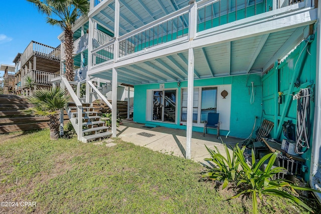 back of house featuring stairway and a lawn