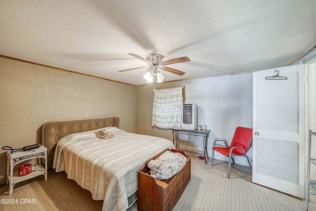 bedroom featuring ornamental molding, a textured wall, a textured ceiling, and ceiling fan