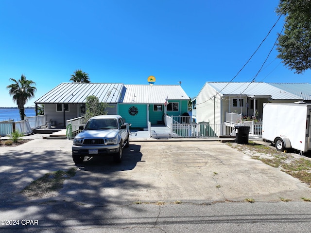 view of front of home featuring metal roof and fence